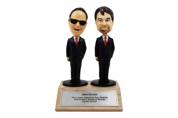 Customized bobblehead figurines mounted on a wooden wedge base with chrome plate